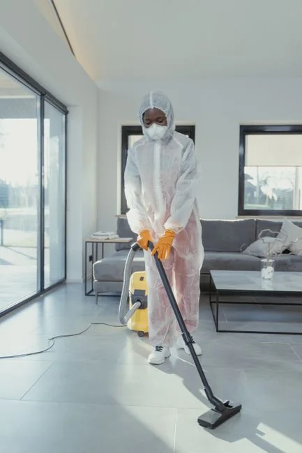 Two cleaning professionals standing back to back in uniform, ready for work.